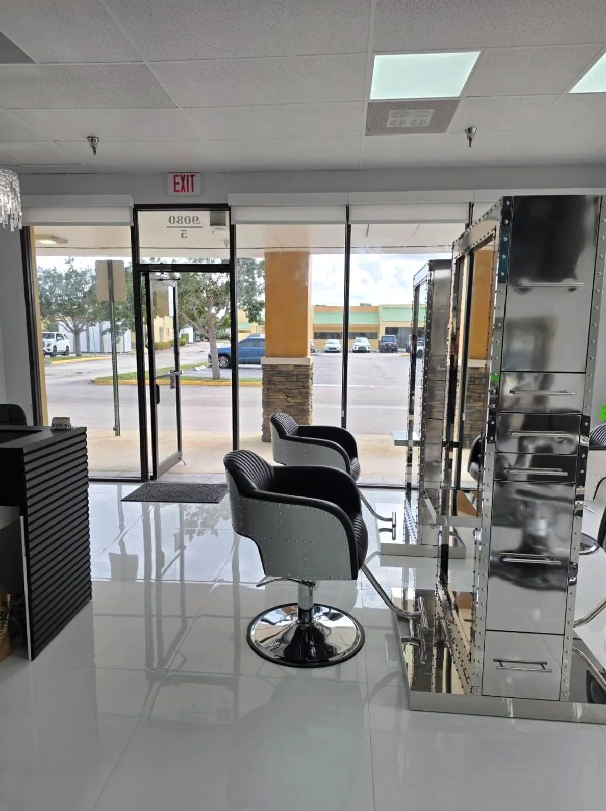 Styling chairs and mirrors beside the salon's glass entrance